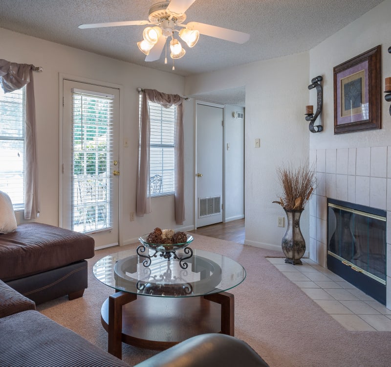 Wood-burning fireplace and a ceiling fan in a model home's living space at The Mansion in Independence, Missouri