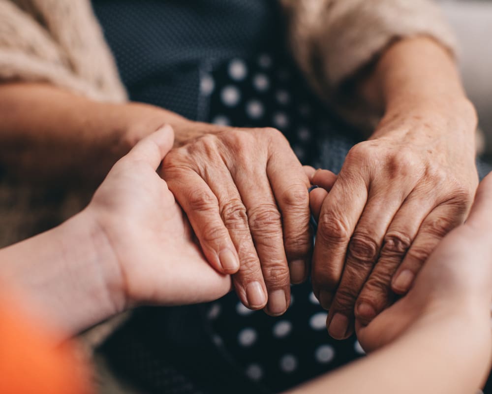 Residents holding hands in a support group at Milestone Senior Living Stoughton in Stoughton, Wisconsin.