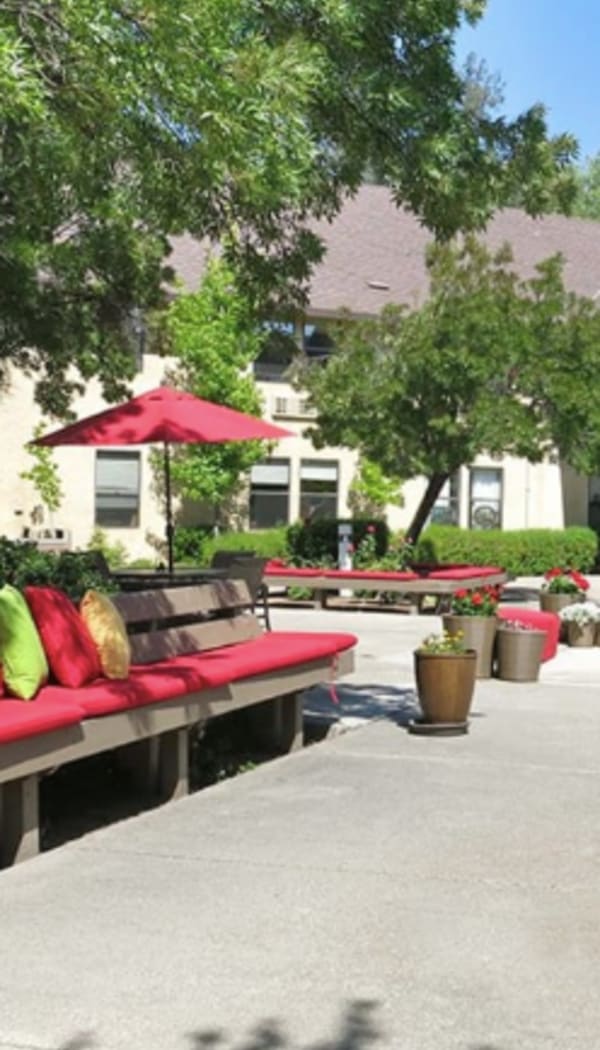Padded outdoor seating under umbrellas near Ray Stone Inc.