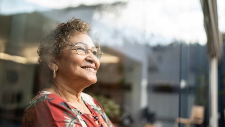 Older woman smiling and looking out a window  
