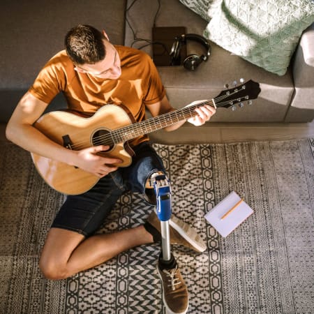 Resident playing guitar in his new apartment at Anatole at City View in Lubbock, Texas