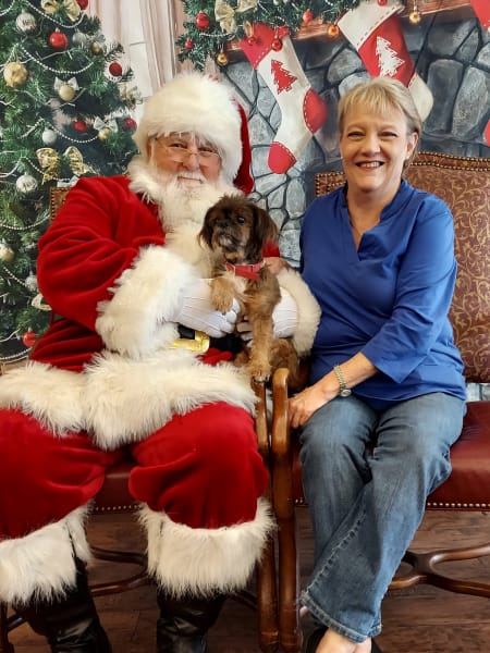 A River Park (TX) resident enjoys her time with Santa and brought along a little furry friend