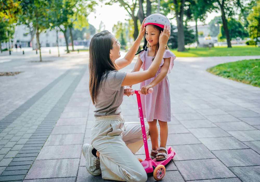 Parent helping child ride a scooter in a park near North Road Townhomes in Scottsville, New York