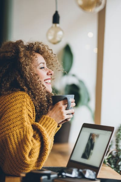 Woman smiling and drinking coffee near Civic Lofts in Denver, Colorado