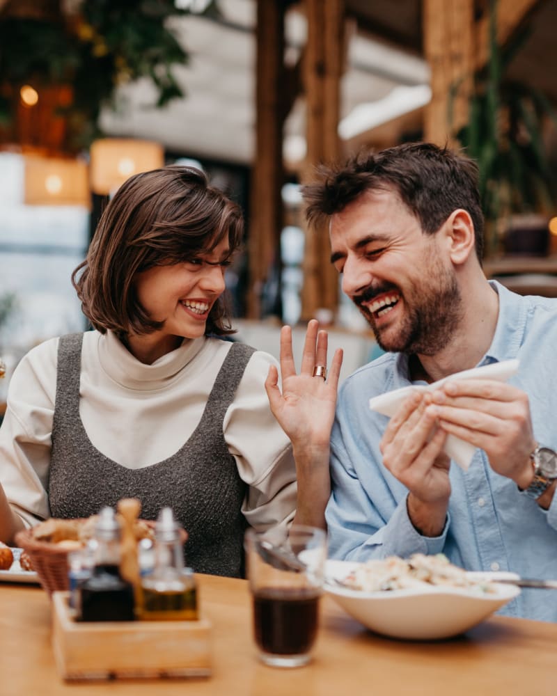 A couple laughing while sitting at a restaurant near Palmetto Circle in North Augusta, South Carolina