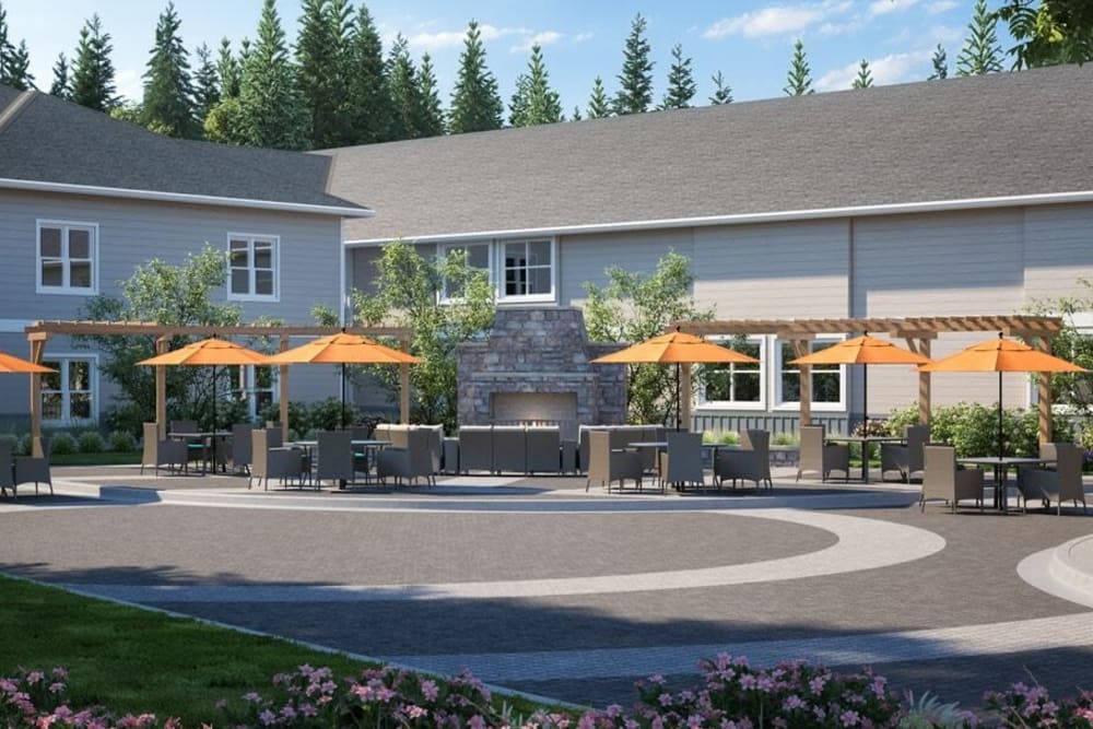 Patio area of upscale senior living facility with cheerful orange umbrellas on a sunny day at The Springs at Sherwood in Sherwood, Oregon