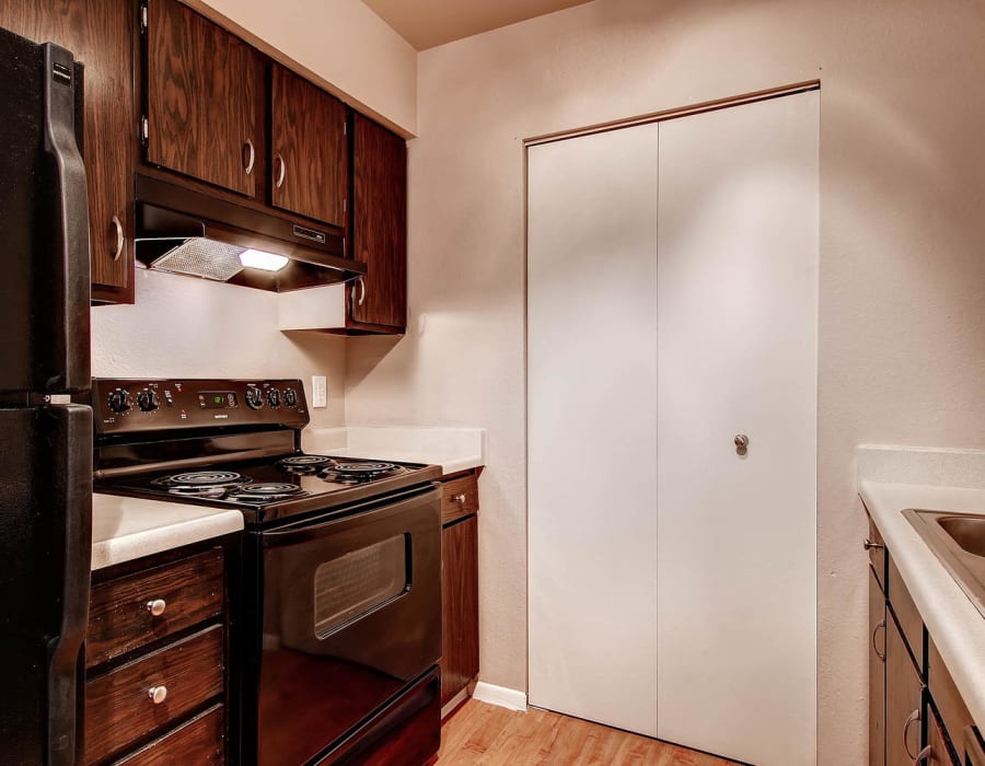 Kitchen with black appliances in a model home at Arvada Village Apartment Homes in Arvada, Colorado