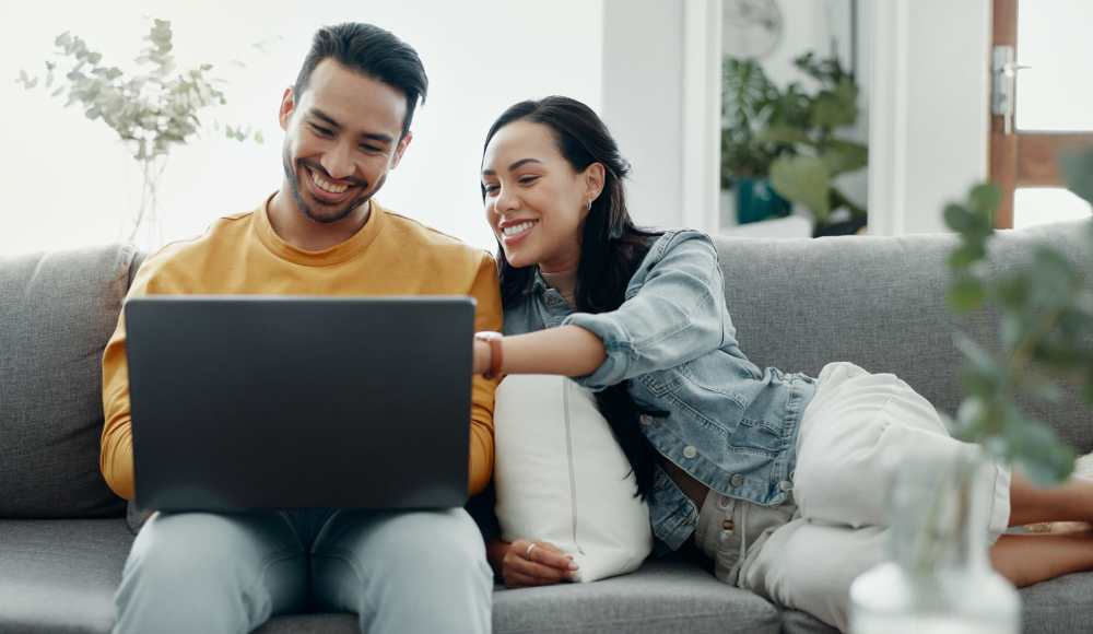Residents using laptop in their living room at Cape Fear Townhomes in Fayetteville, North Carolina