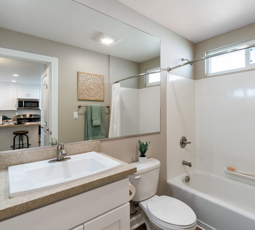 Model bathroom with wood-style flooring at Pinebrook Apartment Homes in Fremont, California