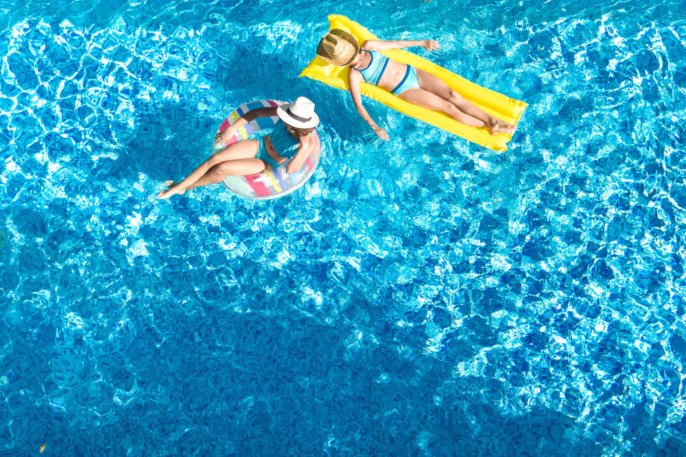 Two residents floating in the swimming pool at Cottage Grove Apartments in Newport News, Virginia
