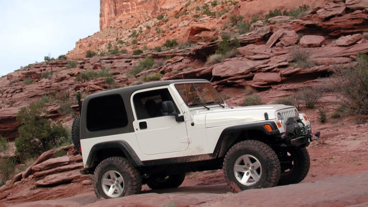 Jeep Rubicon off road surrounded by large red rock cliffs | Unique Tours in Albuquerque