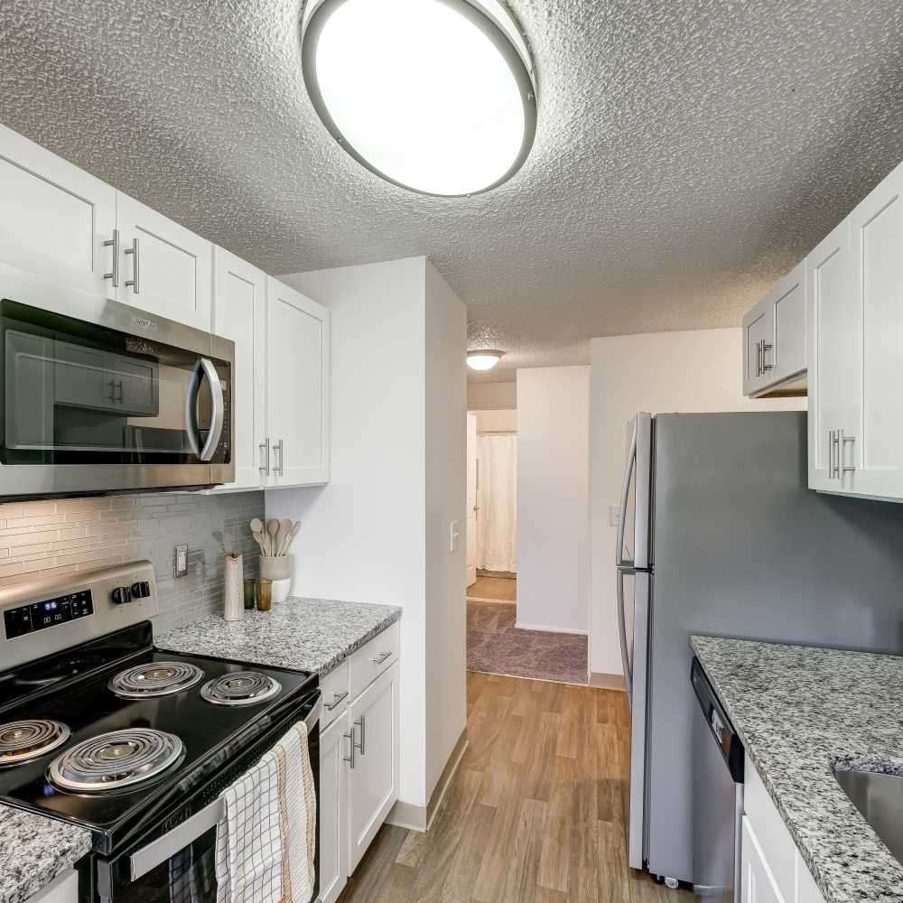 A kitchen with white cabinets and stainless steel appliances in a home at Hilton Village II Apartments in Hilton, New York