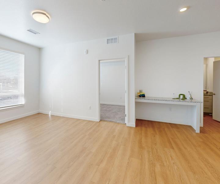 Living room with built-in desk and wood-style flooring at The Rose on Colfax in Denver, Colorado