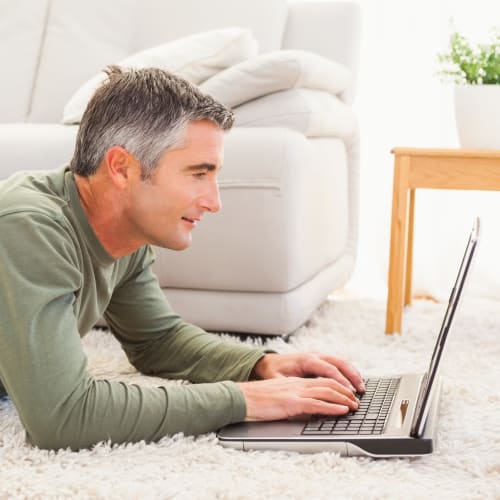 A resident working on hi laptop at Paradise Gardens in San Diego, California