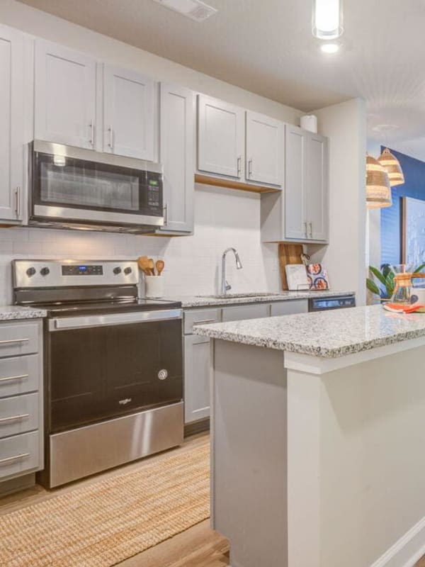 Gourmet kitchen with white cabinetry and stainless-steel appliances at The Hudson at Cane Bay in Summerville, South Carolina