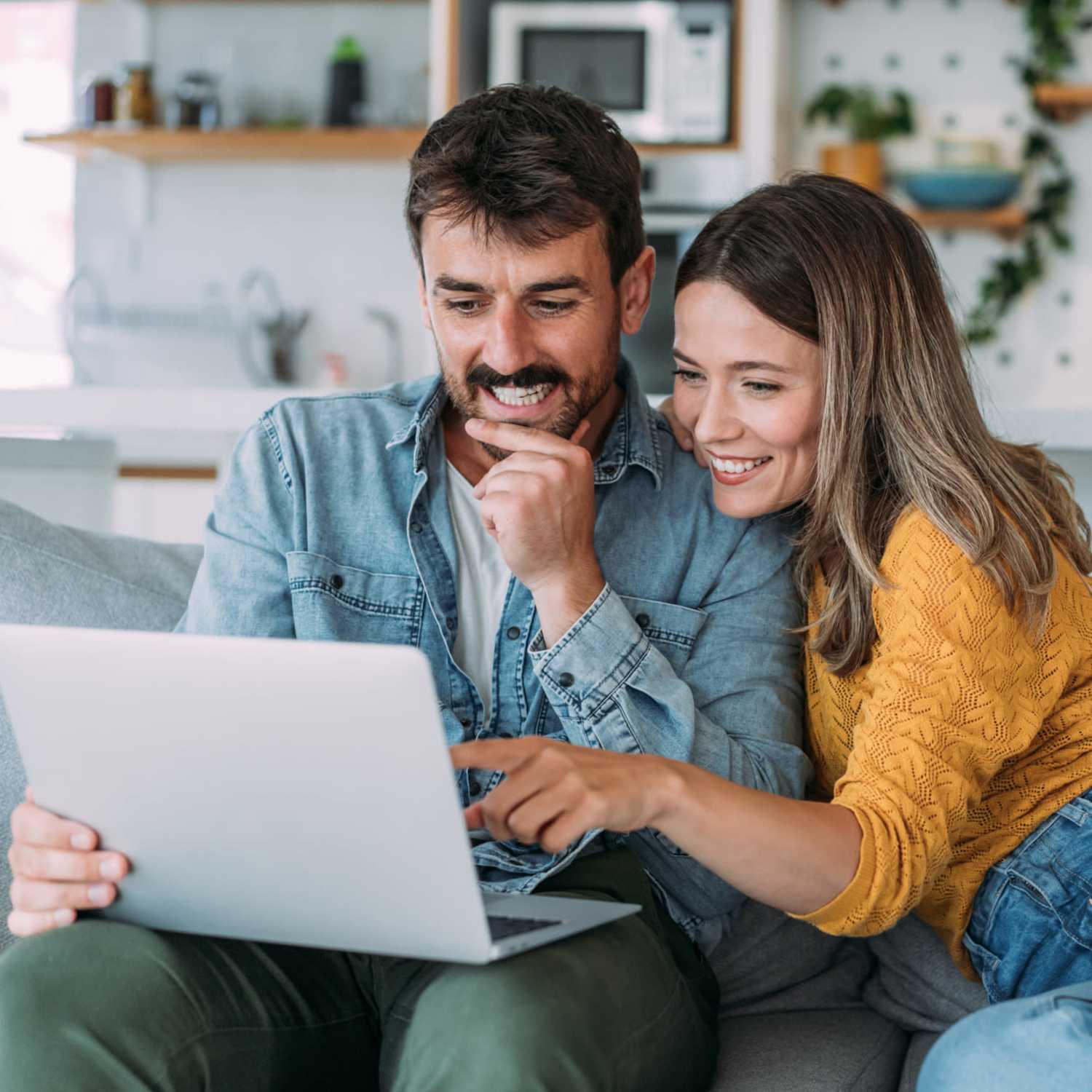 A lovely couple using laptop in their living room at Sherwood Pointe Apartments in Shawnee, Oklahoma