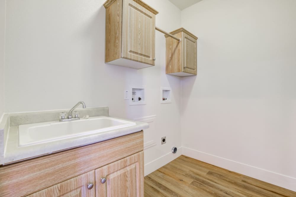 Laundry room with a sink next to washer and dryer at Discovery Village in Joint Base Lewis McChord, Washington