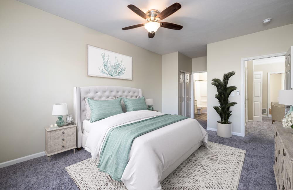 Staged bedroom with wall to wall carpeting and ceiling fan at Christopher Wren Apartments & Townhomes in Wexford, Pennsylvania