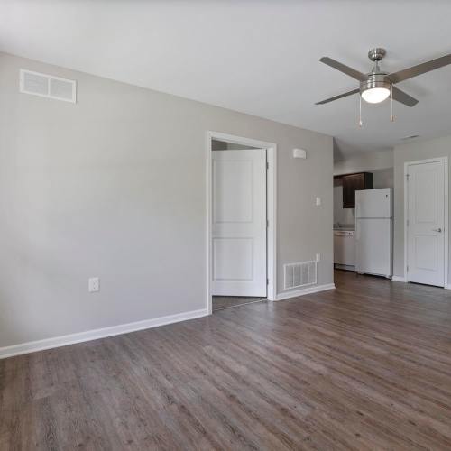A living room with wood-style flooring and a ceiling fan at Wheatland Crossing II in Columbus, Ohio