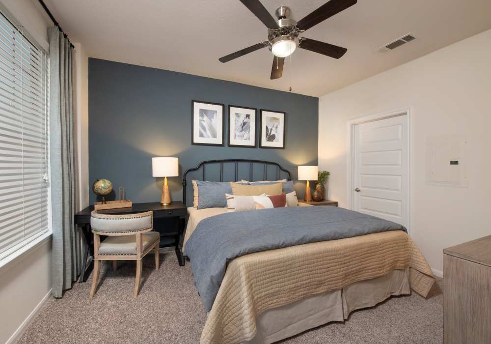 Bedroom with calm and decent bed with ceiling fan at Nantucket at Fannin Station in Houston, Texas