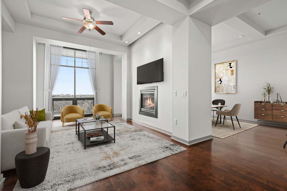 Large living room and dining room with fireplace and tall windows at Kent Place Residences in Englewood,Colorado