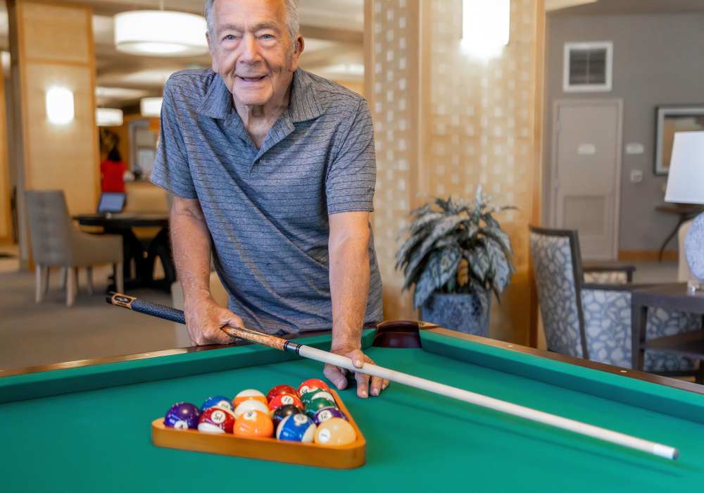 Resident playing pool at Merrill Gardens at Rolling Hills Estates in Rolling Hills Estates, California