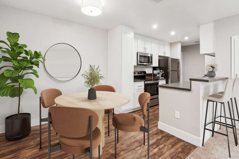 Dining area and kitchen with white cabinets, quartz counters, and stainless steel appliances at Muirwood Apartment Homes in Martinez, California