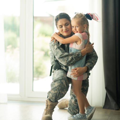 A military mother hugging her daughter in a home at Gateway Village in San Diego, California