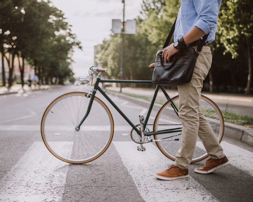 A resident walking across a street with a bicycle near Cascade Village in Joint Base Lewis McChord, Washington