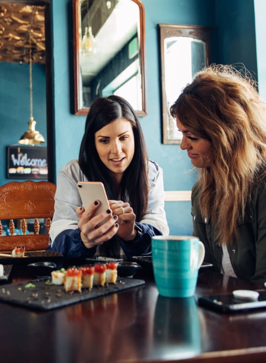 Resident meeting a friend for coffee at a cozy local cafe near Solaire 8200 Dixon in Silver Spring, Maryland