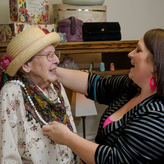 Staff helping a resident try on jewelry at Madonna Gardens in Salinas, California