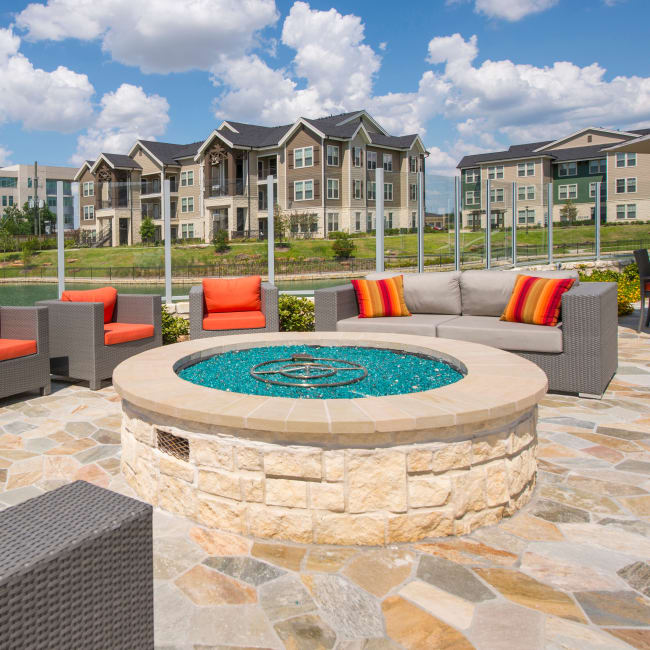 Glass propane fuel fire pit with plenty of comfortable seating at Elite 99 West in Katy, Texas