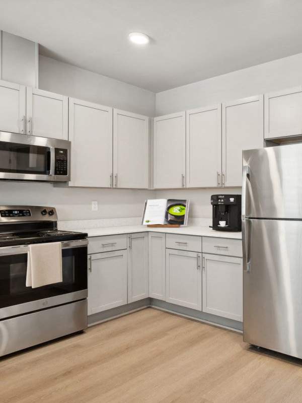 Apartment kitchen with appliances at Village on Main in Tacoma, Washington