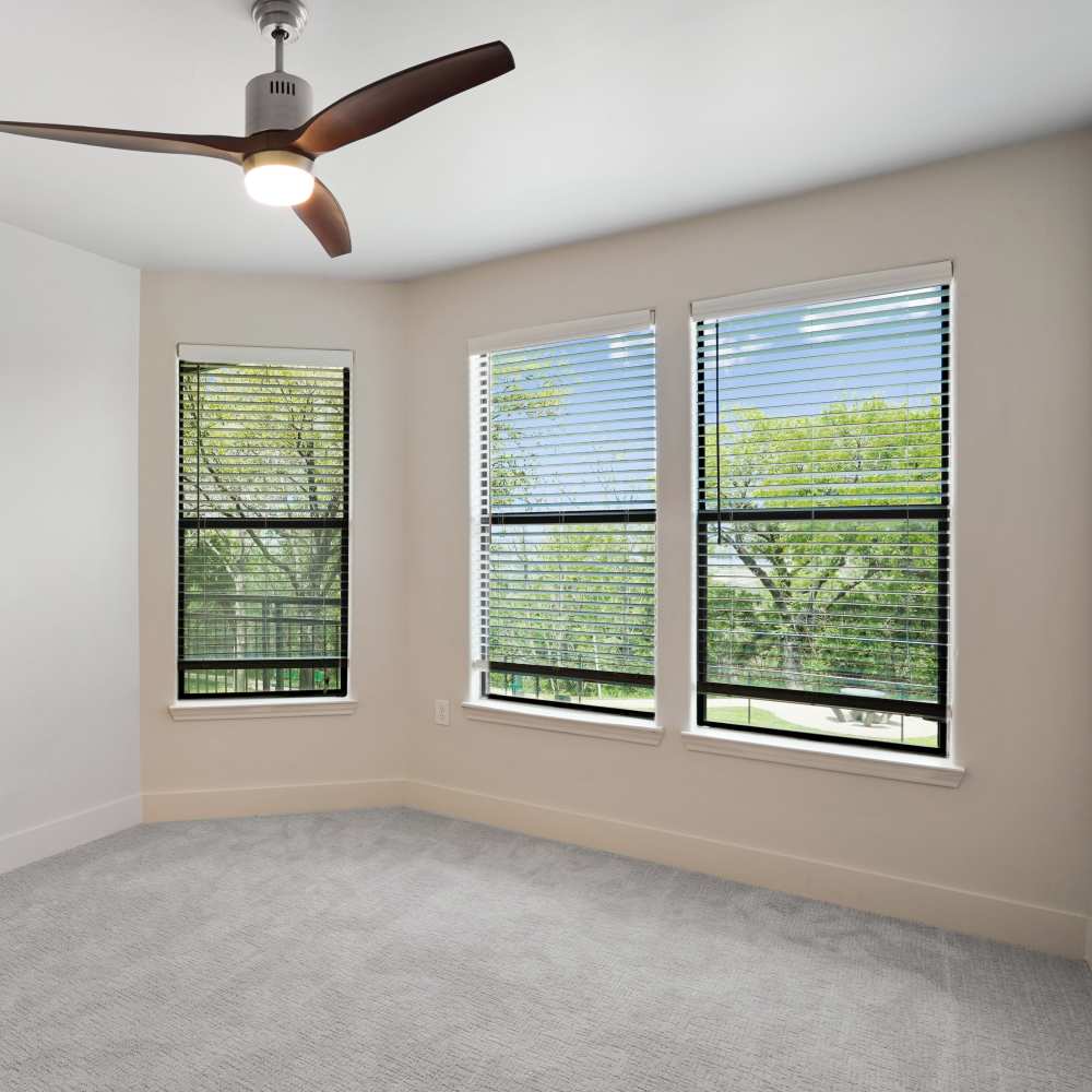 Empty room with ceiling fan and windows at Trinity Bluff & Trinity District in Fort Worth, Texas