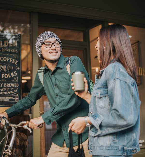 A woman and man talking in front of a coffee shop near Retreat at the Park in Burlington, North Carolina