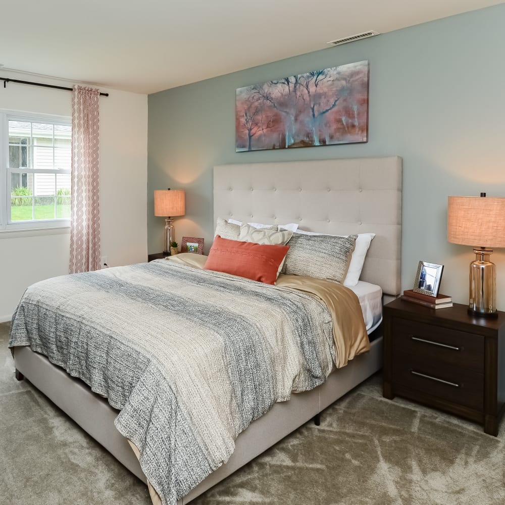 Model bedroom with plush carpeting at Creek Hill Apartments in Webster, New York