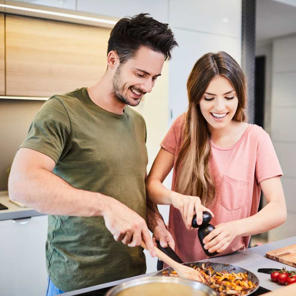 Happy couple cooking at Cherrywood Apartments in West, Texas