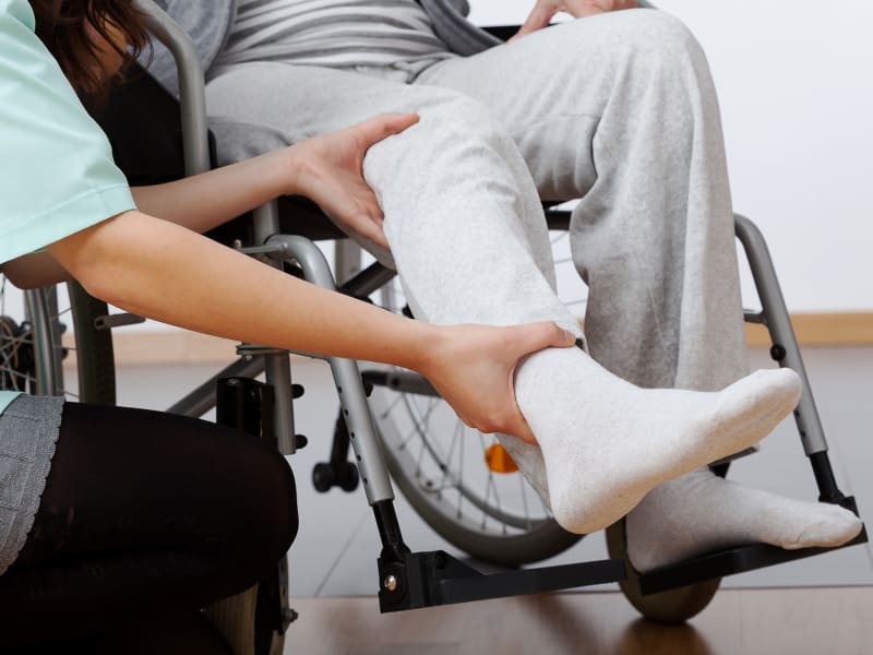 Resident in a wheel chair having feet massaged at Montello Care Center in Montello, Wisconsin