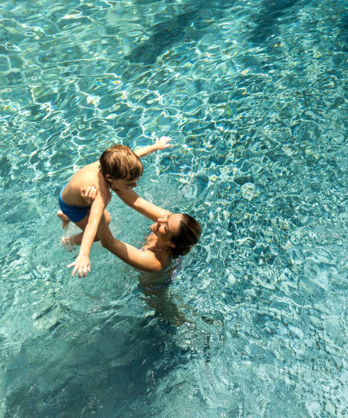 Resident playing with their kid in the pool at The Jessica Apartments, Los Angeles, California 