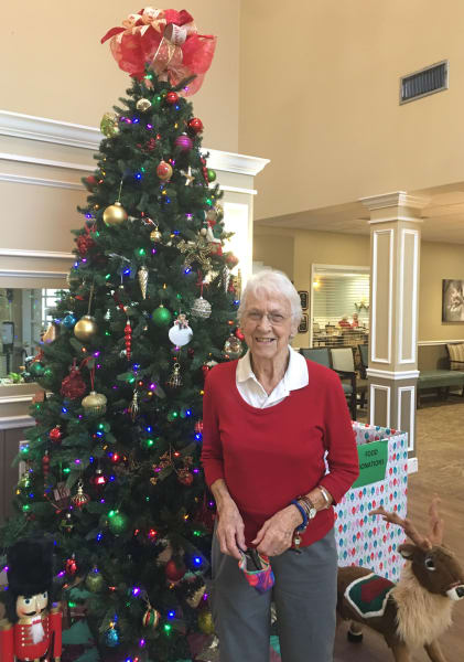 A Barkley Place (FL) resident poses in front of the community Christmas tree.
