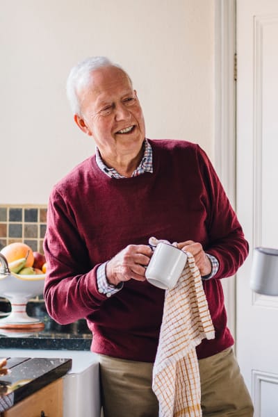 Resident Cleaning a cup in his apartment at Quail Park at Morrison Ranch in Gilbert, Arizona