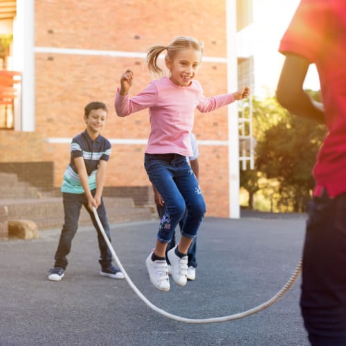 Children playing with a jump rope at a playground near Bayview Hills in San Diego, California