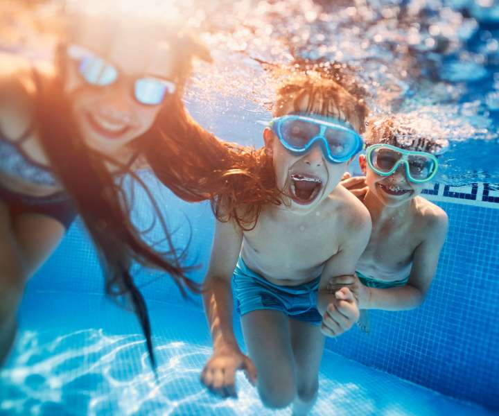 Underwater shot of three children in the community swimming pool at Kirman Garden in Reno, Nevada