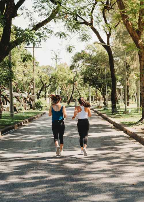 Two women on a run through a tree lined path near Covington Park in Jackson, Mississippi