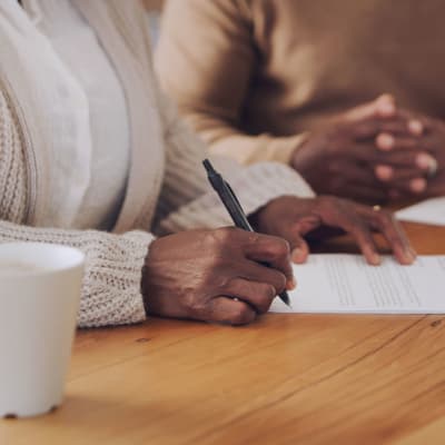 Resident reviewing and signing admission documents at 6th Ave Senior Living in Tacoma, Washington