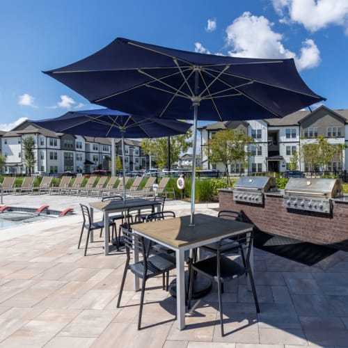 Grills and covered tables by the pool at Indigo Champions Ridge in Davenport, Florida