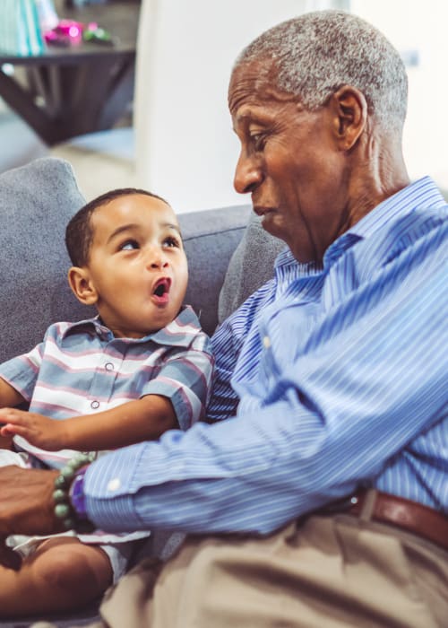 Resident reading a book with their grandchild at Armstrong Memory Care Assisted Living in Warren, Ohio