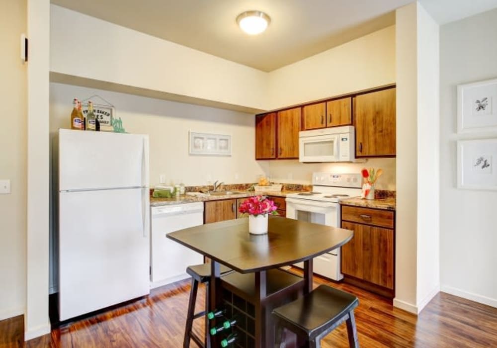 Spacious kitchen with white appliances and wooden cabinetry at LARC at Olympia in Olympia, Washington