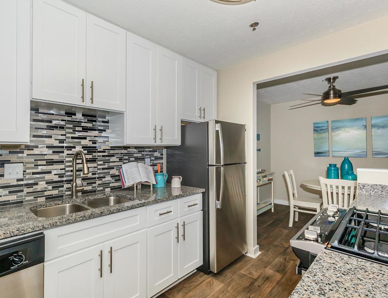 Model home's gourmet kitchen with a subway tile backsplash and granite countertops at The Bentley at Marietta in Marietta, Georgia