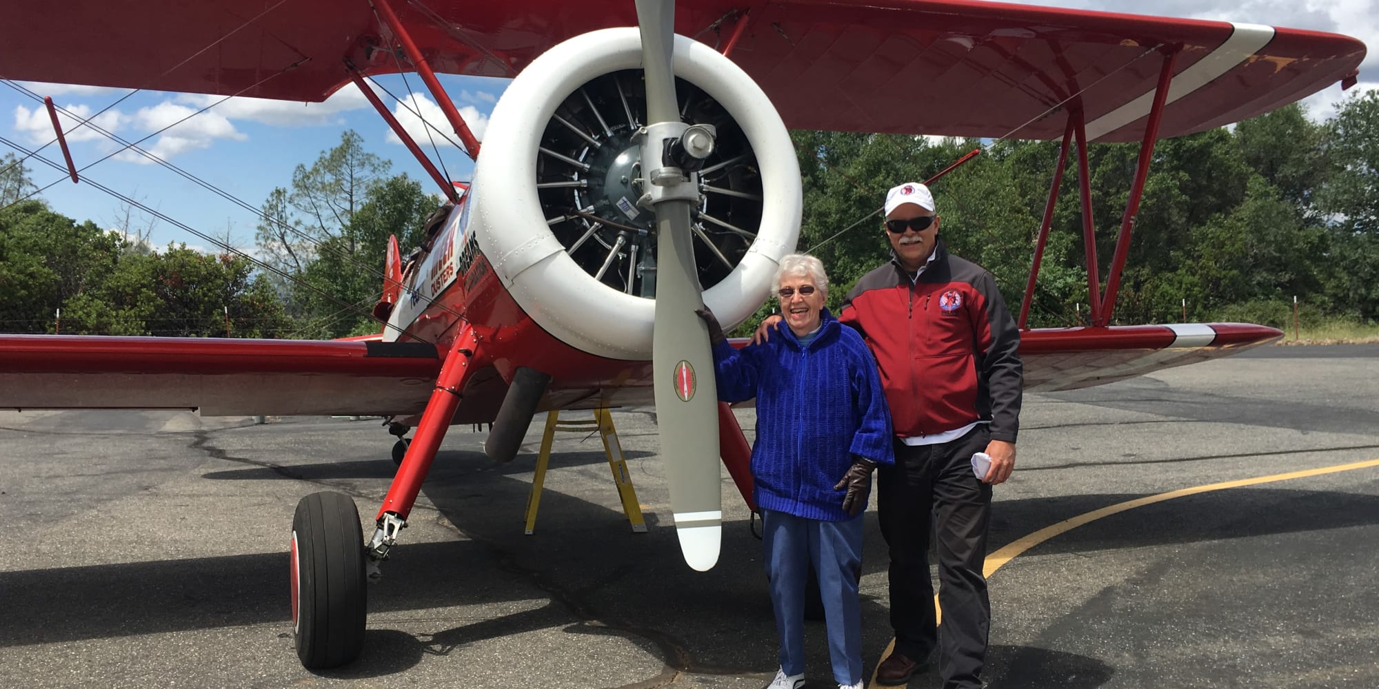 Residents of Alexis Estates Gracious Retirement Living pose by an airplane in Allen, Texas